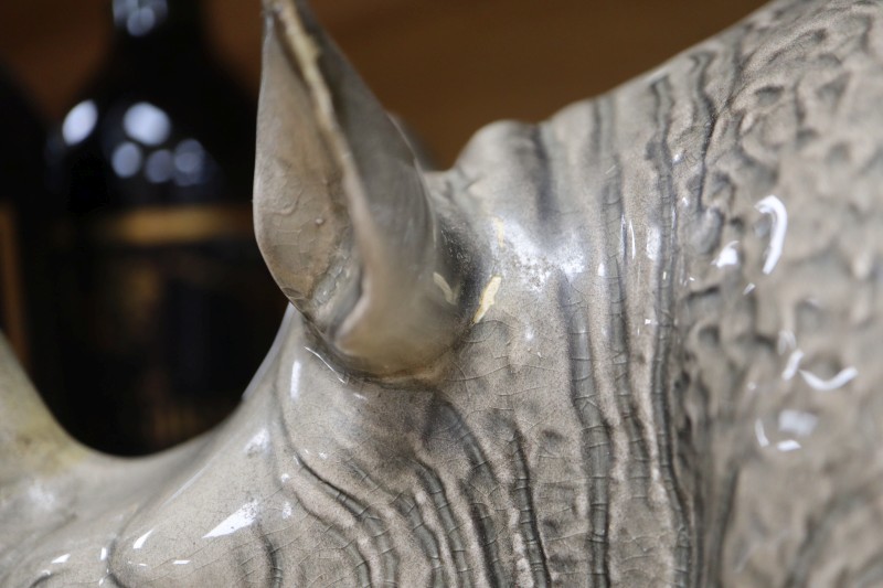 A Melba ware porcelain rhinoceros, height 20cm (a.f.), the broken end of horn is present